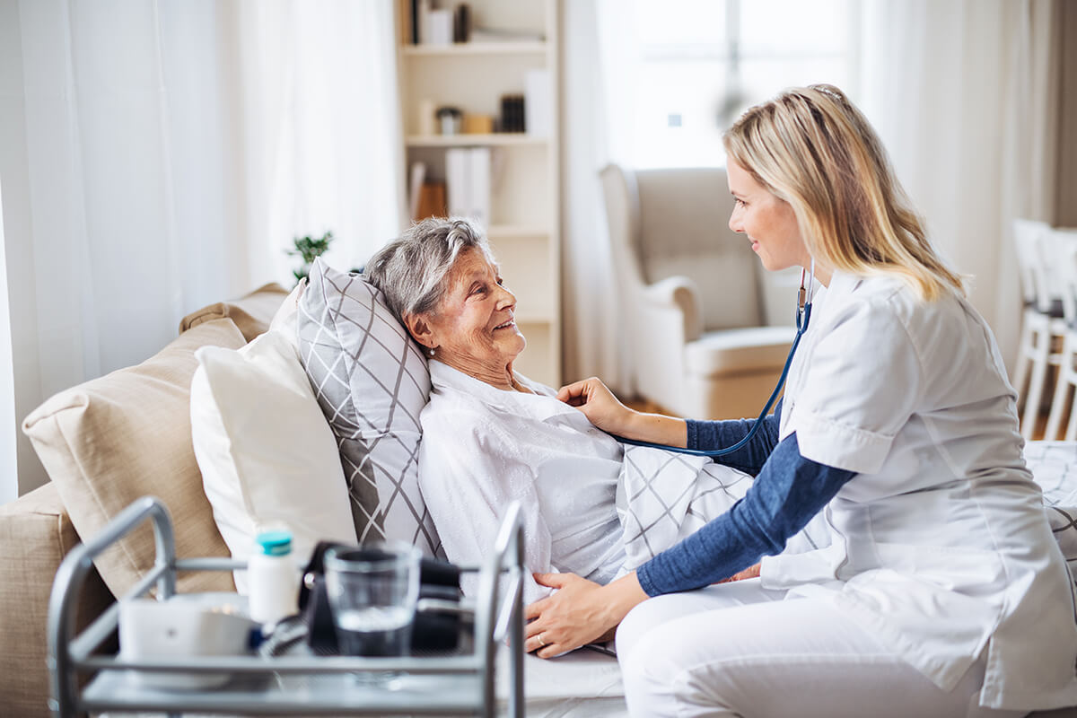 A health visitor examining a sick senior woman