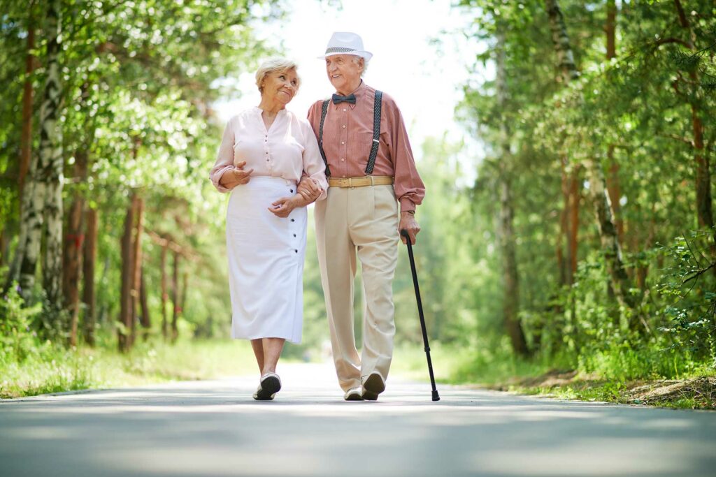 two elderly people walking down the road