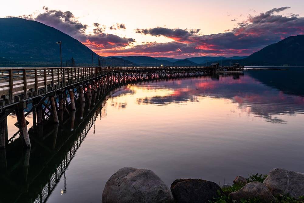 Dramatic Sky over a Curving Pier on a Mountain Lake at Dusk Dramatic Sky over a Curving Pier on a Mountain Lake at Dusk